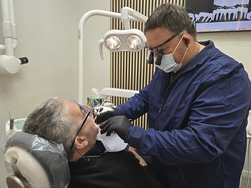Dentist performing dental bonding treatment on patient in modern Brooklyn dental office
