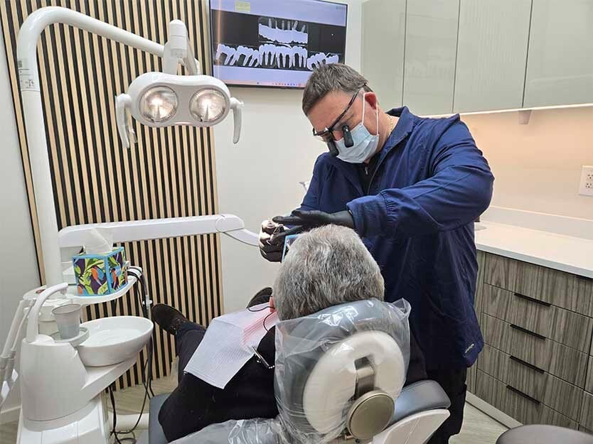 Dental hygienist reviewing a digital intraoral scan with a patient at VitaDent Brooklyn Dental Group.