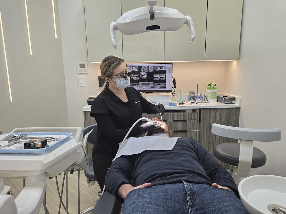 Dentist examining gums during gingivitis treatment at VitaDent Brooklyn Dental Group