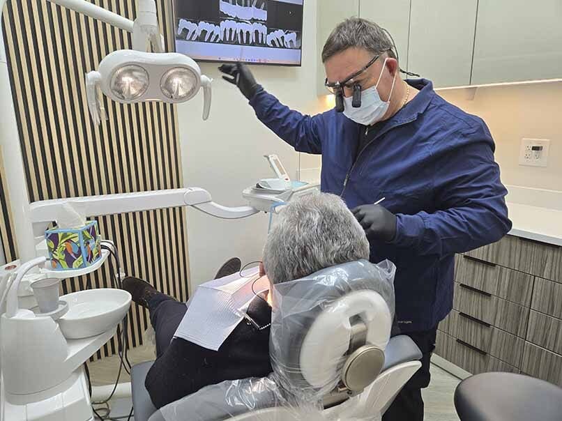 Dentist reviewing dental X-rays during laser gum surgery consultation in Sheepshead Bay, Brooklyn