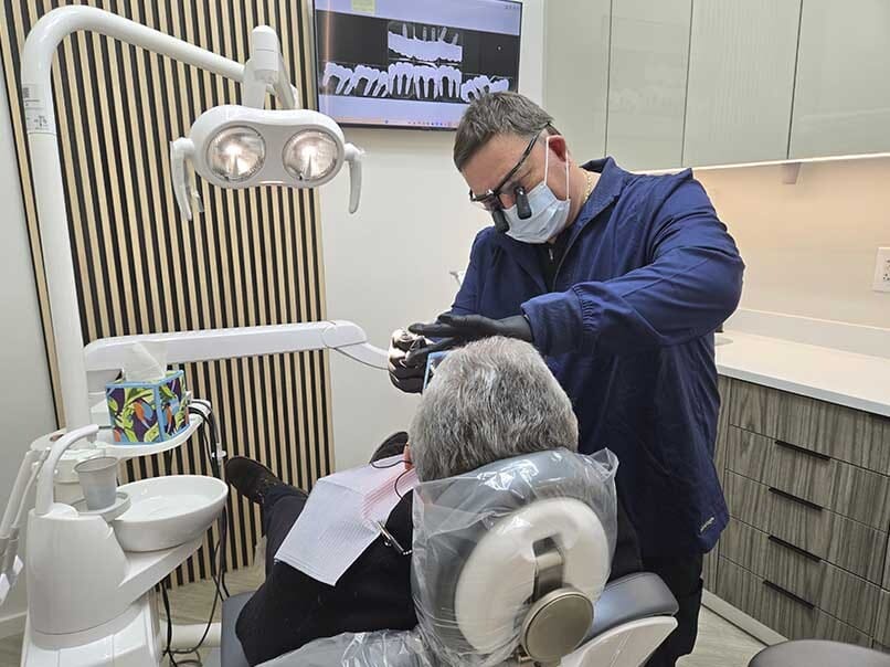Oral surgeon performing a dental surgical procedure in a modern treatment room at VitaDent Brooklyn.