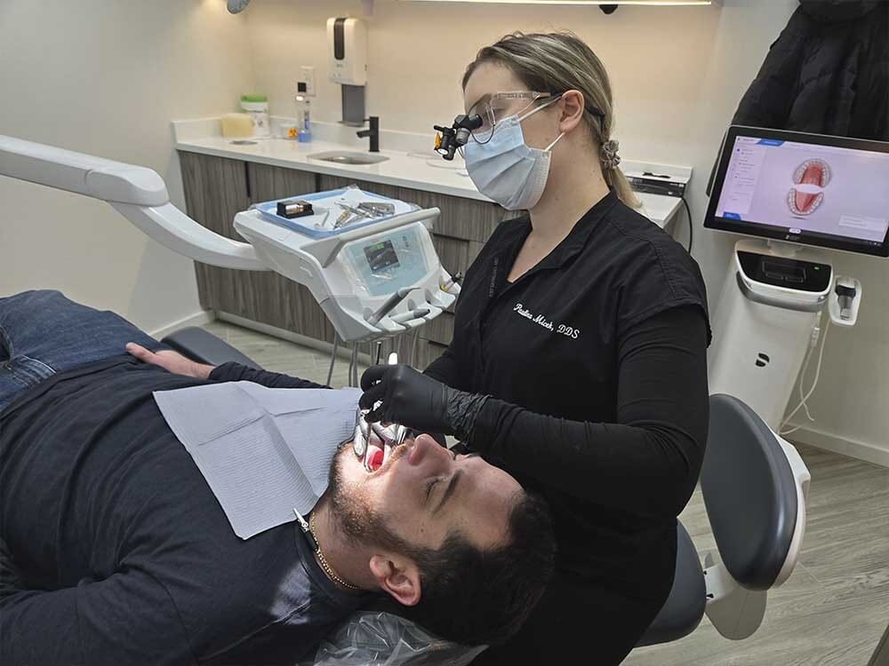 Dental hygienist performing professional teeth cleaning at VitaDent Brooklyn in Sheepshead Bay